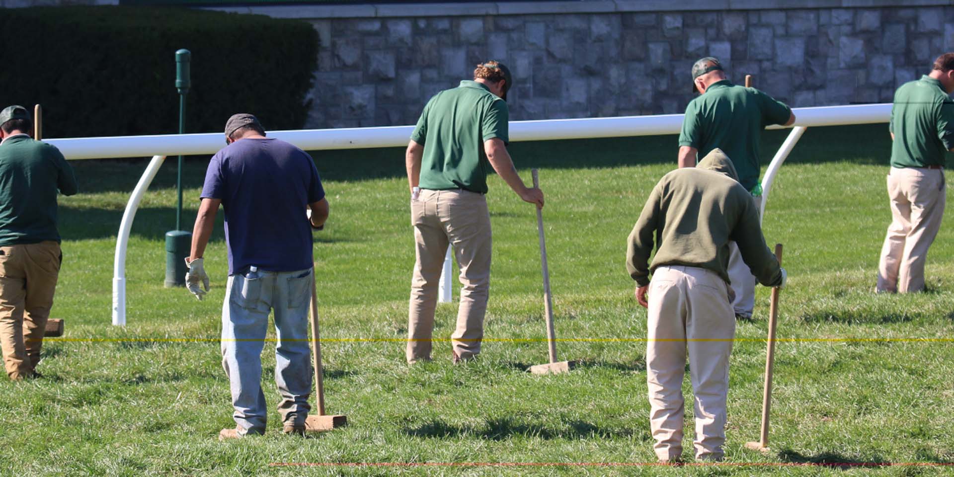 An action shot of Kneevalleytracks team members tamping down turf divots.